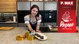 Konditormeisterin Sarah präsentiert lächelnd die fertigen Cookie-Dough-Brownies in einer modernen Küche. Auf einem weißen Teller vor ihr sind mehrere saftige Brownie-Stücke angerichtet.