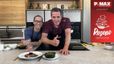 Chefkoch Peter Lehner und Gast Philipp Jelinek präsentieren lächelnd das fertige Gericht in einer modernen Küche. Peter Lehner gibt einen Daumen nach oben, während das Rib Eye Steak mit Beilagen auf der Arbeitsplatte vor ihnen angerichtet ist.